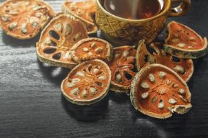 Dried herbs and dried bael fruit, Slices of bael fruit on table. photo