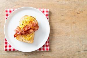 tostada de pan con huevos revueltos y tocino foto