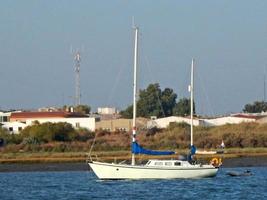 Small white sailing ship near the shore photo