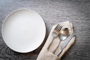 Empty plate or dish with knife, fork and spoon photo