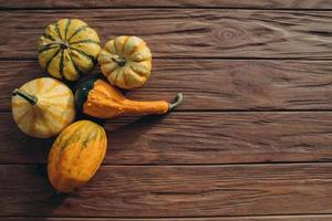 Pumpkins, dried leaves on white wooden background top view. Autumn. photo