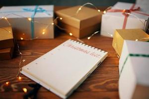 Wooden table with gift boxes and notepad photo