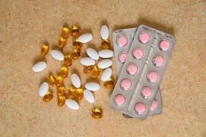 blister with pink tablets and vitamin D and capsules with fish oil photo