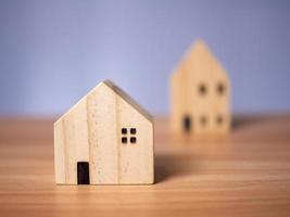 Two wooden model houses placed on a wooden table. photo