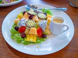 Ensalada de verduras en un plato blanco colocado sobre un fondo de madera. foto