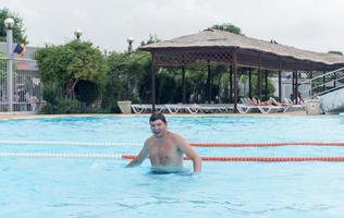 Hombre disfrutando de nadar en la piscina del parque acuático
