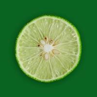 rodaja de limón y lima y cítricos frescos sobre fondo verde.