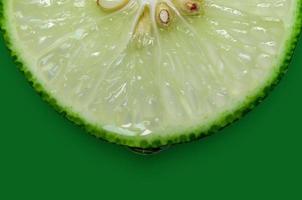 Lemon and lime slice and fresh citrus fruit on green background. photo