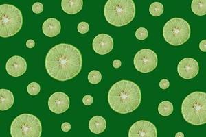 Lemon and lime slice and fresh citrus fruit on green background. photo