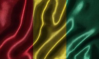 papel tapiz con bandera de Guinea y bandera ondeando con tela. foto