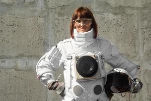 Mujer astronauta sin casco en el fondo de una pared gris