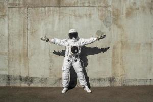 Futuristic astronaut in a helmet against gray walls photo