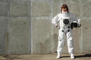 Mujer astronauta sin casco en el fondo de una pared gris foto