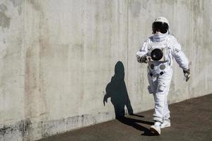 Futuristic astronaut in a helmet against gray walls photo