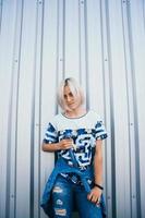 woman with short white hair stands on the background of metal wall photo
