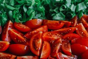 Chopped tomatoes and bright green spinach as a background texture
