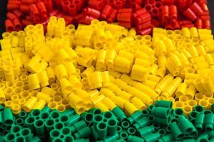 Plastic bricks of red, yellow and green. Details of toys. Close up.