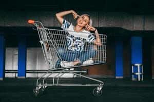 woman dressed in jeans with shopping carts in the parking lot photo