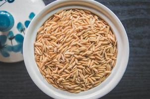 Fondo y papel tapiz por pila de arroz con cáscara y semillas de arroz. foto