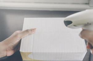 A human hand holding parcel with barcode reader for delivery. photo