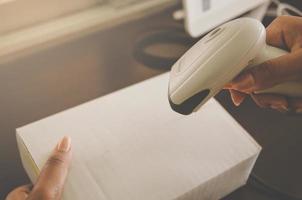 A human hand holding parcel with barcode reader for delivery. photo