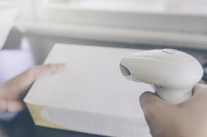 A human hand holding parcel with barcode reader for delivery. photo