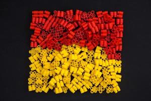 Plastic bricks of yellow and red on a black background photo