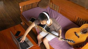 menino aprende a tocar violão online em casa video