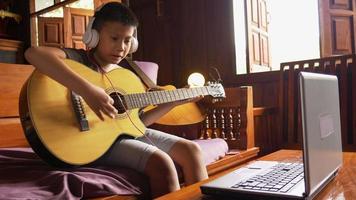 Boy learns to play guitar online  at home
