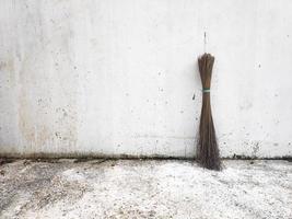 Broom stick on white wall background photo