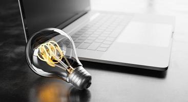 Light bulb next to a laptop photo