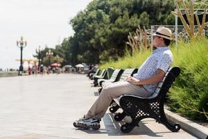 Young man on the bench on the sea, having a rest and enjoying the view photo