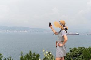 mujer tomando fotos del paisaje urbano con teléfono móvil