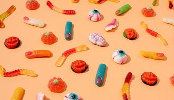 Colorful sweets for Halloween party on orange background