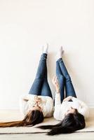 Two women laying at the rug legs up having fun photo