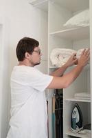 Young man ironing at home photo