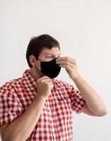 Young man putting on a protective mask photo