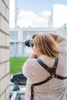 Retrato de mujer con sobrepeso tomando fotografías con una cámara en el exterior foto