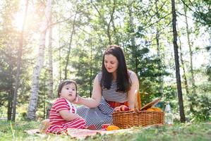 Familia interracial de madre e hija en el parque haciendo un picnic