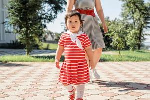 Feliz familia multirracial de madre e hija caminando en el parque foto