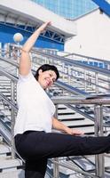 Smiling senior woman doing stretching outdoors on urban background photo