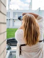 Retrato de mujer con sobrepeso tomando fotografías con una cámara en el exterior foto