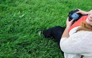 Retrato de mujer con sobrepeso tomando fotografías con una cámara en el parque foto