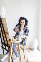 Mujer creativa con pintura de cabello teñido de azul en su estudio foto