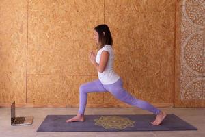 Young woman standing with hands in anjali mudra position photo