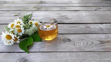 Chamomile tea and a bouquet of chamomiles photo