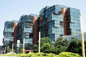 Modern apartment or office building in city center with green lawn on a sunny summer day photo