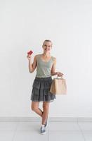 Smiling woman holding eco friendly shopping bags and credit card photo