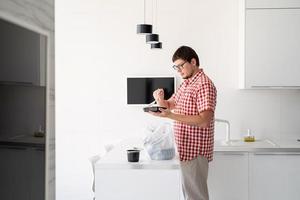 Man holding a disposable plastic bag with food delivery at the kitchen photo