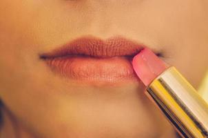 Beauty face of woman by applying lipstick on mouth by cosmetics.